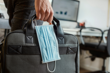 Business Confidence as UK Lockdown Eases. Office worker carrying briefcase and mask.